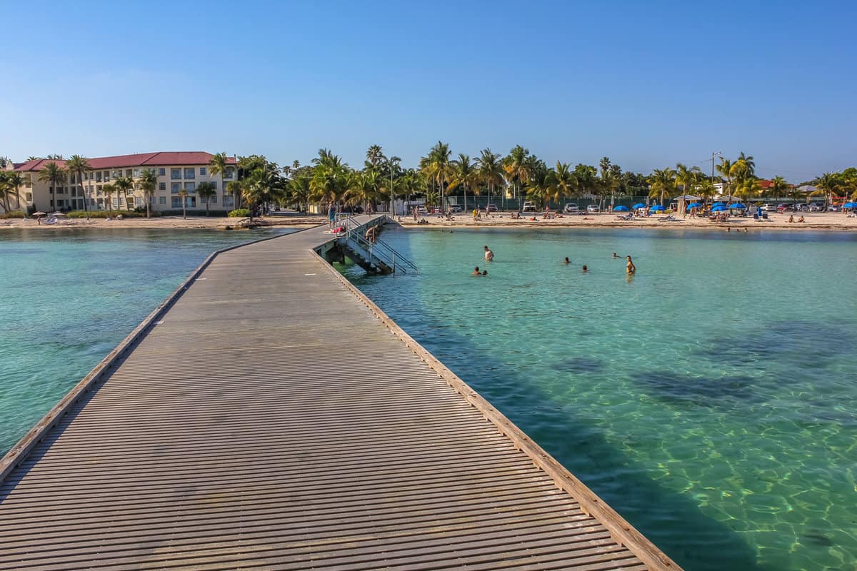 Wooden pier in Higgs Beach, a popular Key West beach in Florida known for snorkeling, tropical turquoise waters and white sand. Summer vacation in the tropics. Relaxing and summertime concept.
