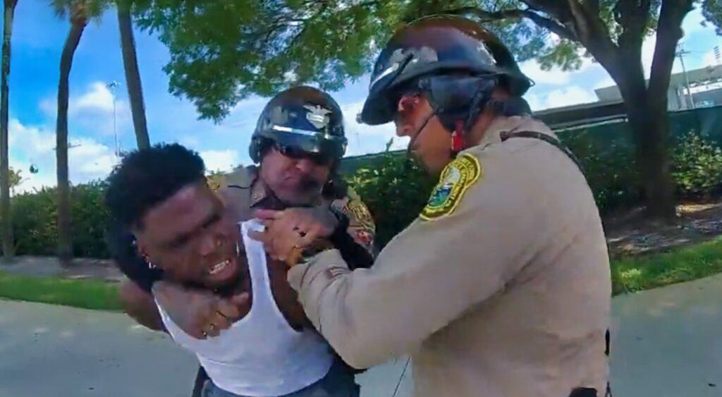 Tyreek Hill of Miami Dolphins being handcuffed by officers.